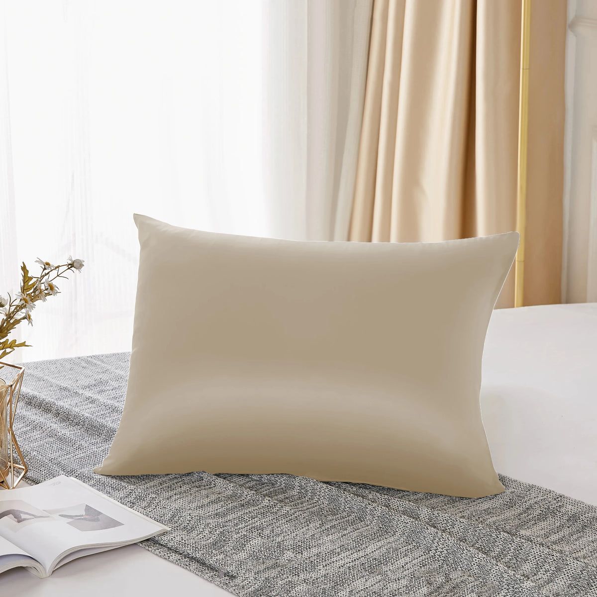 Housse de couette en soie naturelle de couleur crème sur un tissu gris texturé.