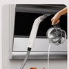 A white multifunctional steam cleaner is shown with a visible water level line, being used to clean inside an oven.