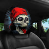 A pair of skull and red hat themed car seat headrest covers are shown inside a car.