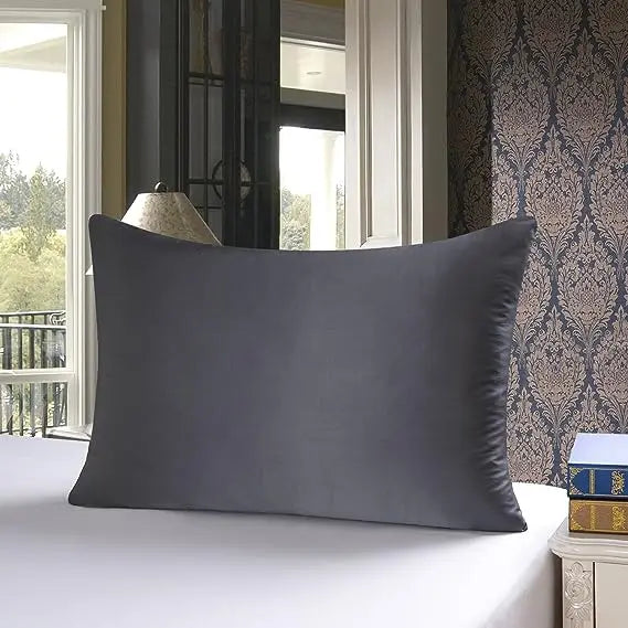 Housse de couette en soie naturelle pourpre et grise posée sur un lit blanc dans une pièce bien éclairée.