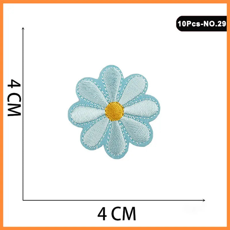 Light blue embroidered flower patch with a yellow center on a white background.