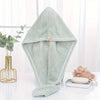 A light mint green microfiber towel wrap for hair is displayed on a white surface.