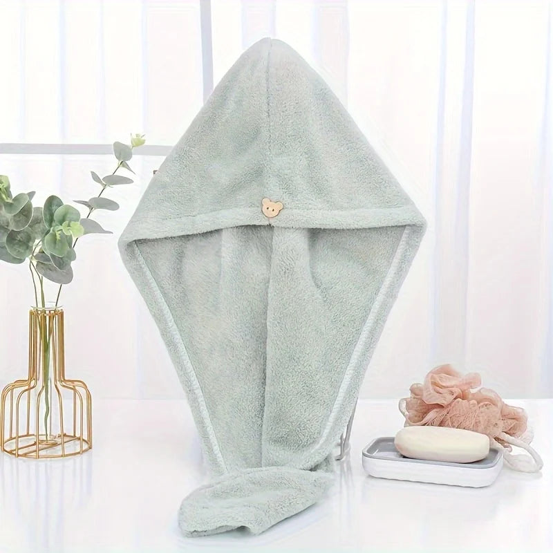 A light mint green microfiber towel wrap for hair is displayed on a white surface.