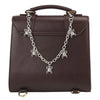 A dark brown leather handbag with an elegant silver metal chain strap featuring a dragonfly charm.