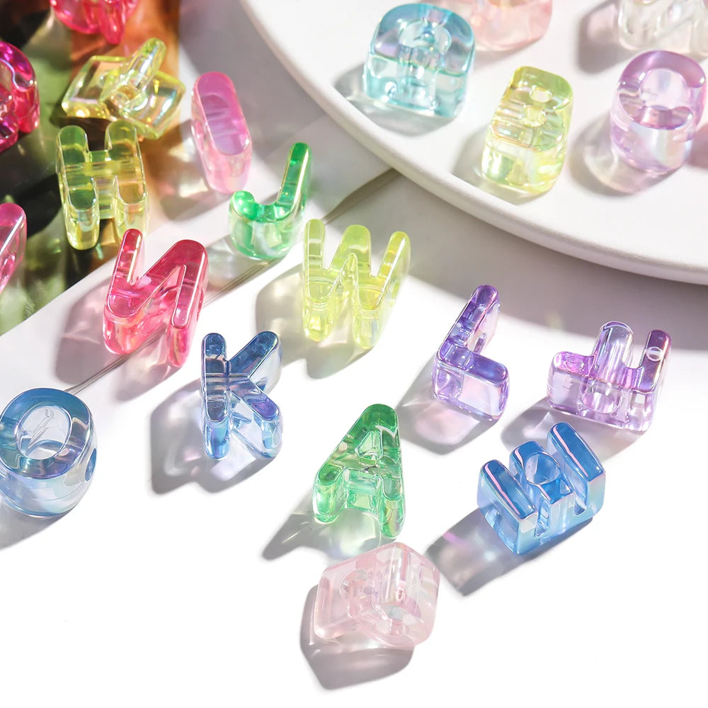A collection of colorful acrylic alphabet beads in various shapes and colors arranged on a white surface.