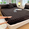 A dark brown luxury faux fur fitted sheet and pillowcase set is displayed on a bed with natural light.