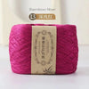 A skein of magenta bamboo fiber yarn labeled as dark pink, ready for knitting or crochet.