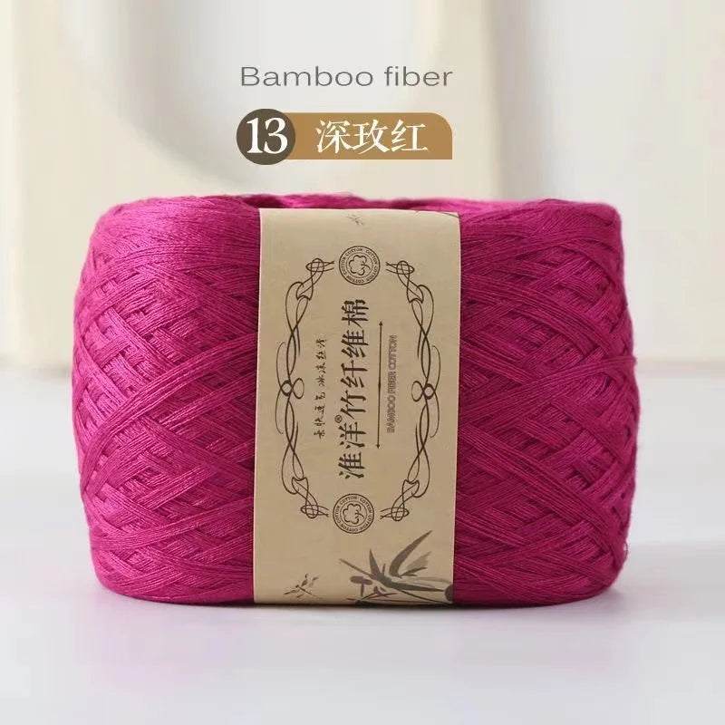 A skein of magenta bamboo fiber yarn labeled as dark pink, ready for knitting or crochet.