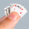A hand holds a fan of mini playing cards showing various numbered and face cards.