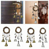 A set of witch bells door hangers and wind chimes hanging on a wooden door.