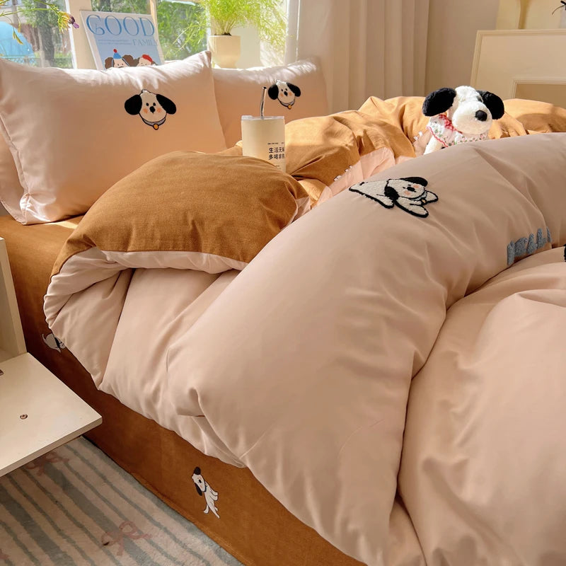 A set of light pink and tan cartoon embroidered duvet covers featuring dog faces.