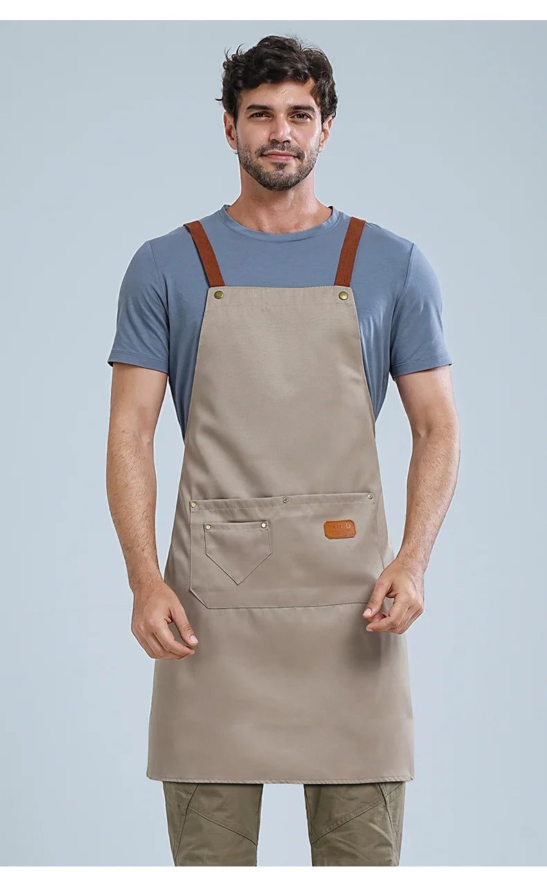 A man wearing a beige waterproof adjustable kitchen apron over a blue t-shirt.