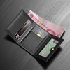 A black leather card holder wallet displaying various credit cards and a banknote on a dark gray surface.