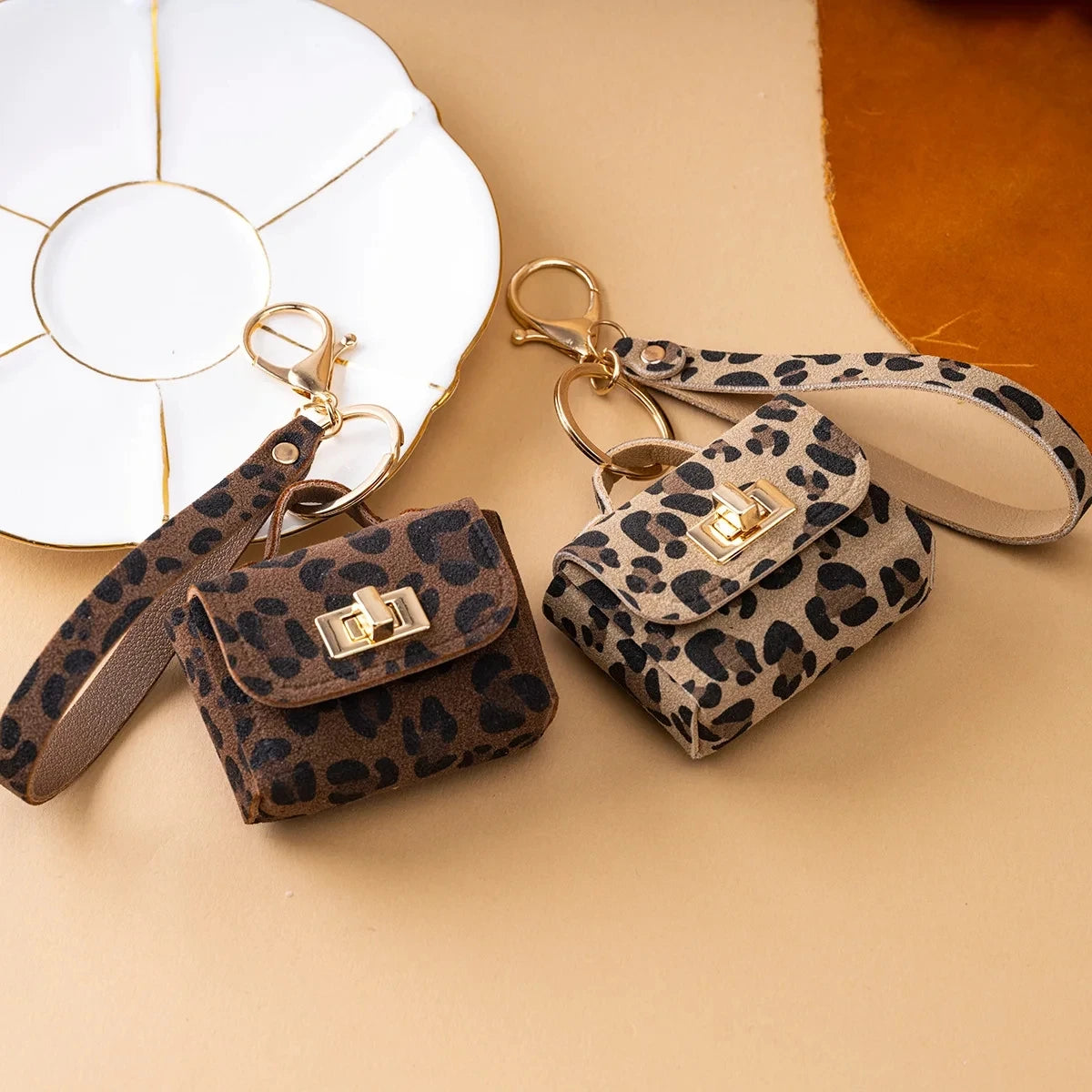 A leopard print PU leather mini wallet and keychain are displayed on a beige background next to a white ceramic plate.