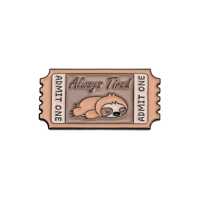 A vintage enamel brooch featuring the text Always Tired and Admit One with a sleeping bear design.