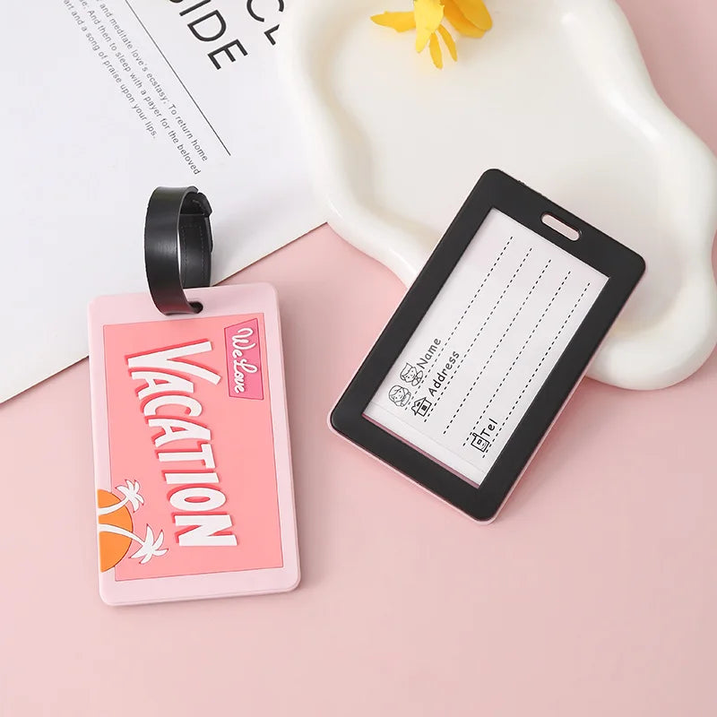 A pink silicone luggage tag with a letter design is shown next to a black strap on a light pink background.