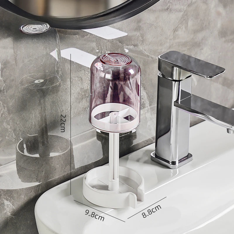A modern bathroom toothbrush holder with a dust cover and drainage system mounted on a white ceramic surface.