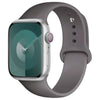 A silver Apple Watch encased in a gray silicone sport band.