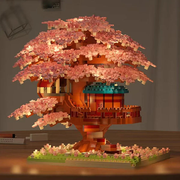 Un ensemble de bâtiment d'un arbre à fleurs de cerisier avec des fleurs roses et un tronc orange, équipé de lumières LED.