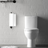 A white ceramic toilet is mounted on a gray brick wall next to a wall-mounted paper towel holder.