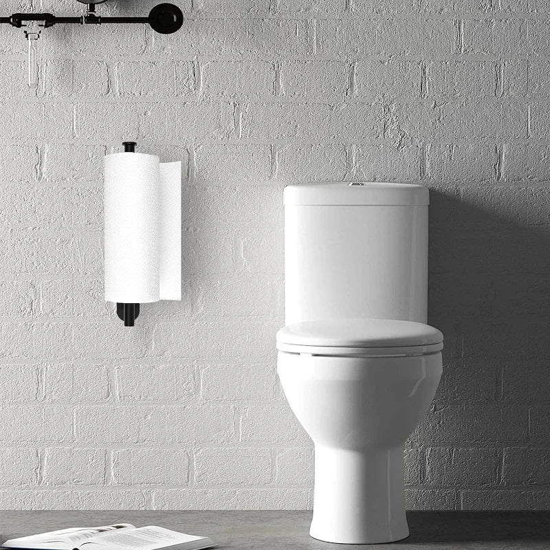 A white ceramic toilet is mounted on a gray brick wall next to a wall-mounted paper towel holder.