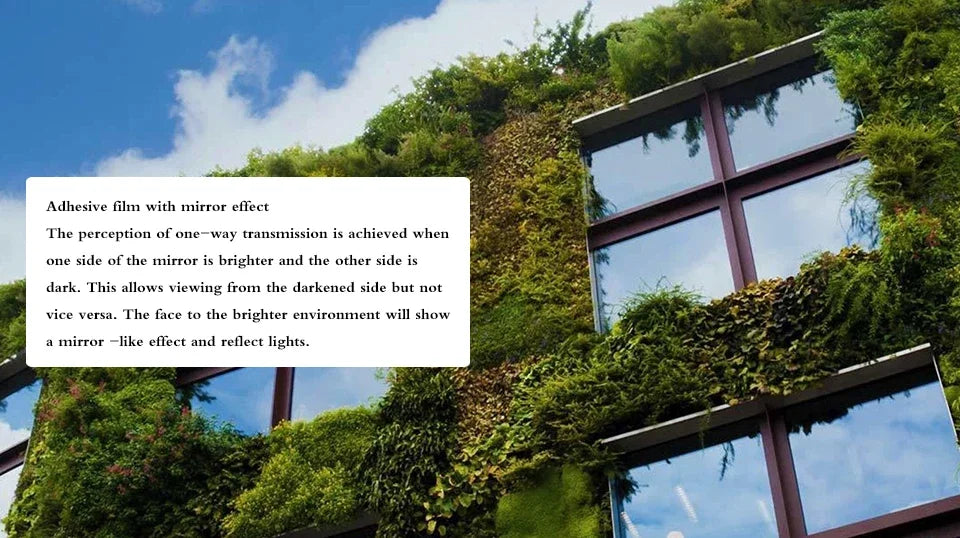 Adhesive film with mirror effect on a building facade covered in green ivy.