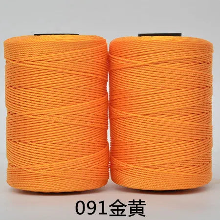 Two spools of bright orange 3-ply polyester knitting yarn for crochet and hand crafts
