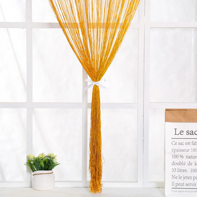 A vertical curtain made of bright golden yellow beaded thread hanging in a doorway.
