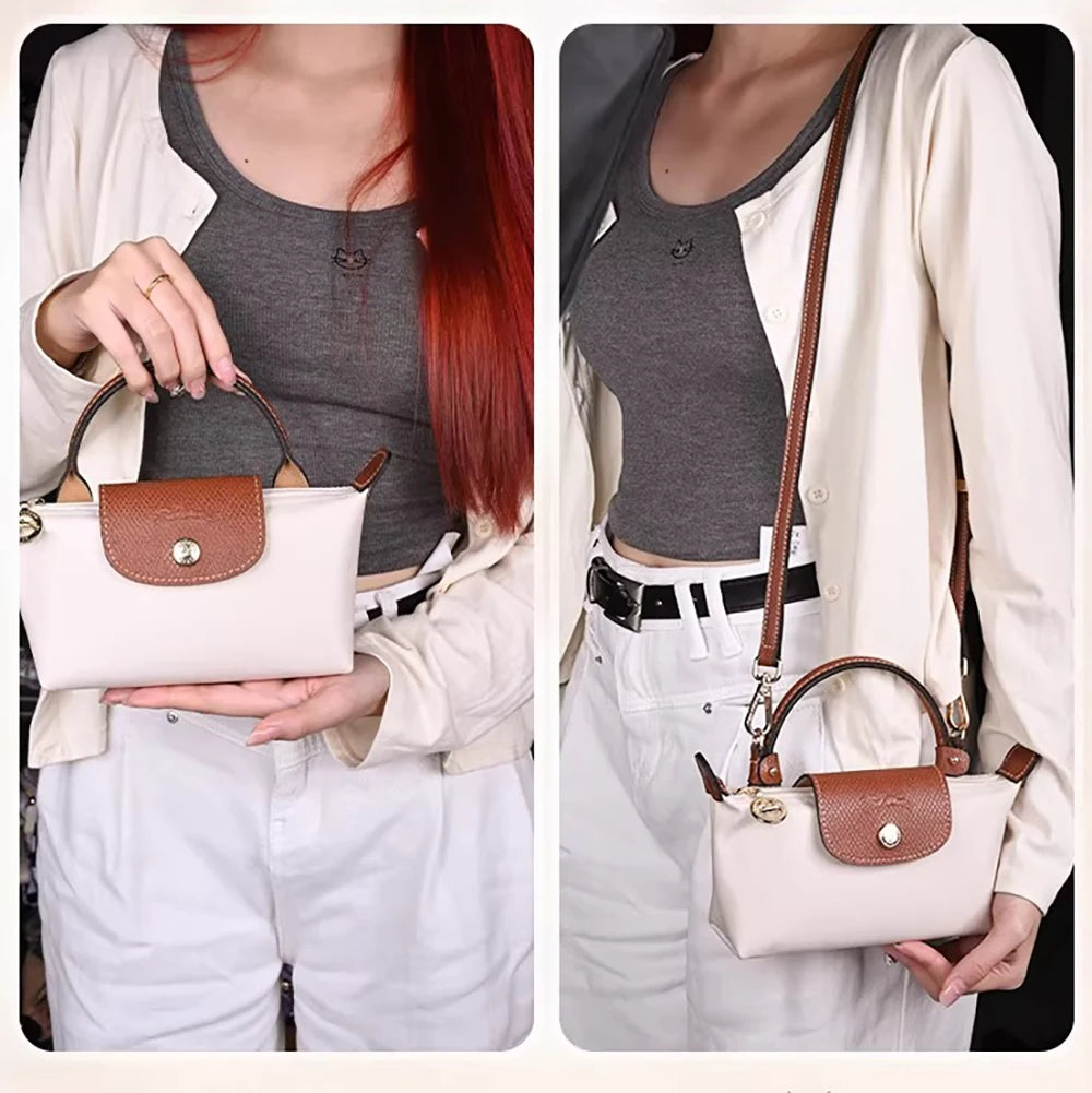 A woman models a beige shirt and white pants while holding a light beige leather mini bag with a brown strap.