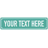 A rectangular teal metal sign with white text that reads YOUR TEXT HERE.