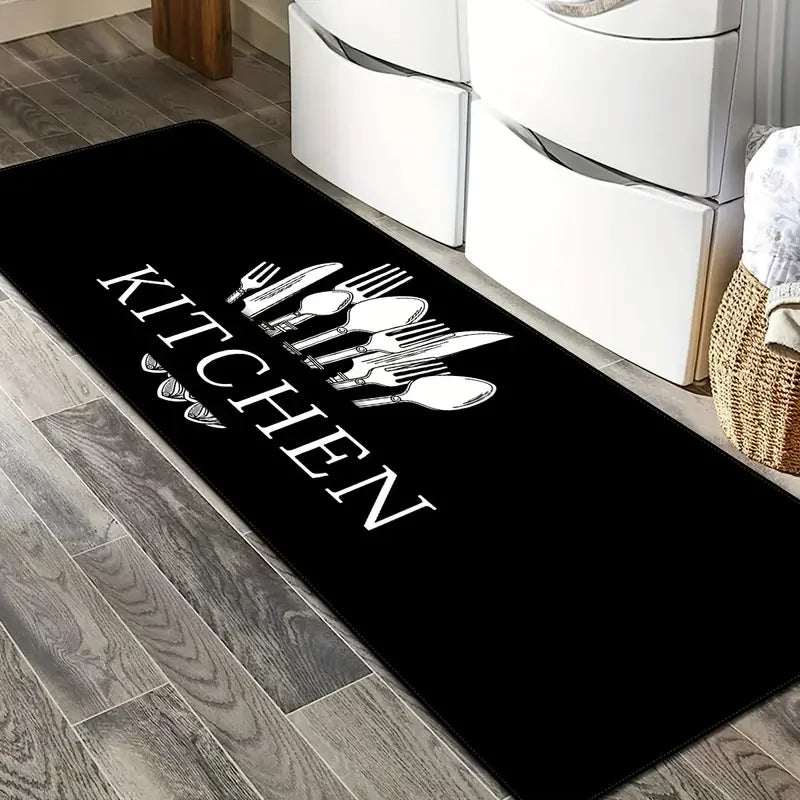 Black non-slip waterproof kitchen mat with silverware silhouette design placed on a wooden floor.