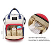 A beige and blue insulated canvas mummy diaper bag with a hanging hook and interior compartments.