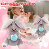 A gray elephant plush toy is shown with musical notes, being played by a smiling baby in a soft pink setting.