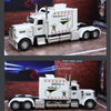 A white 1:24 scale diecast Peterbilt 389 heavy truck model with pull-back action, sound, and lights displayed on a brick back