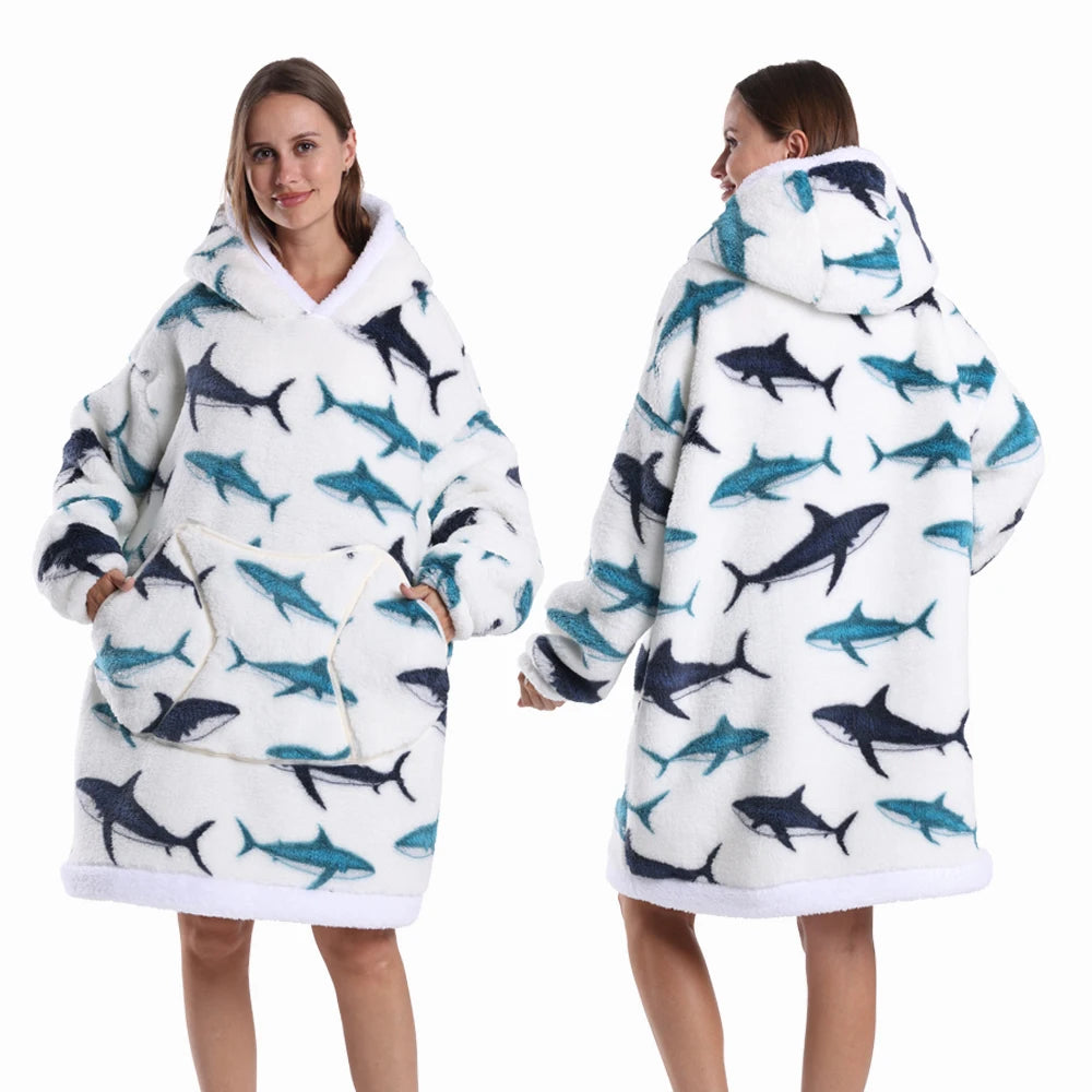 Eine Frau modelliert einen überdimensionierten Fleece-Hoodie mit weiß-blauer Musterung und Kapuze.