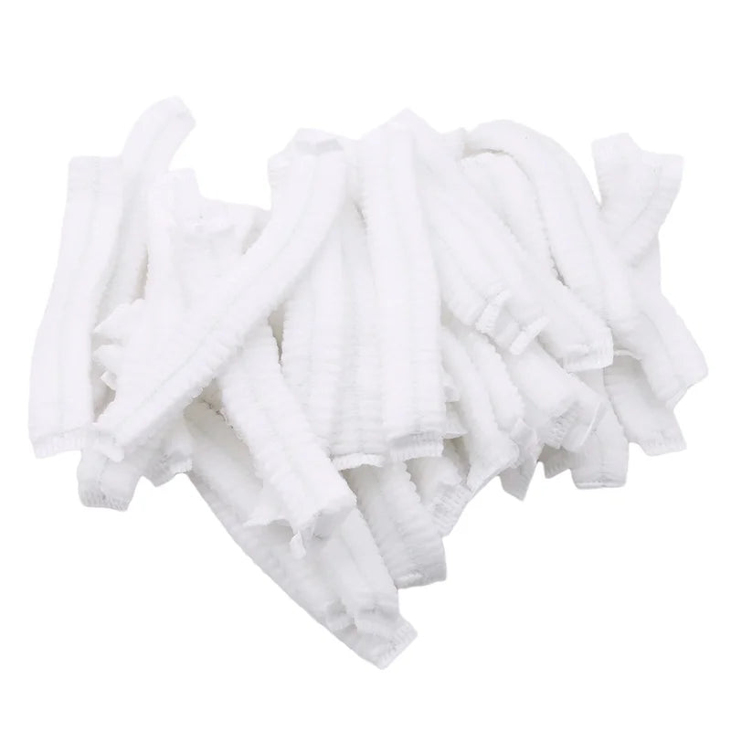 A pile of white disposable non-woven hair net caps.