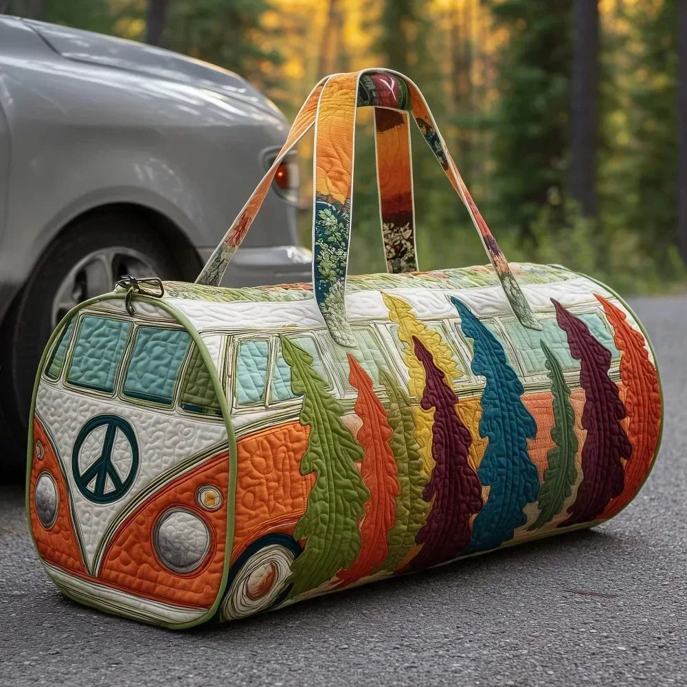 A quilted travel duffle bag featuring colorful, nature-inspired stitching and leather handles resting on an asphalt surface.