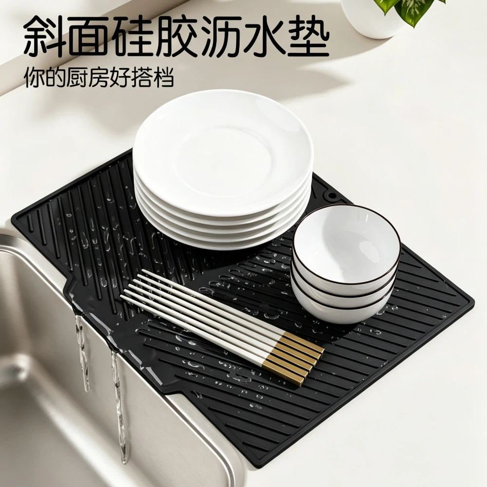 Black silicone dish drying mat with silicone strands and a stack of white plates placed on a stainless steel sink.