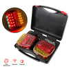 A black storage case containing a red LED trailer tail light and a remote control, showing the light's illumination.
