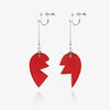 A pair of red stone pendants on silver chains, featuring a jagged, heart-like shape.