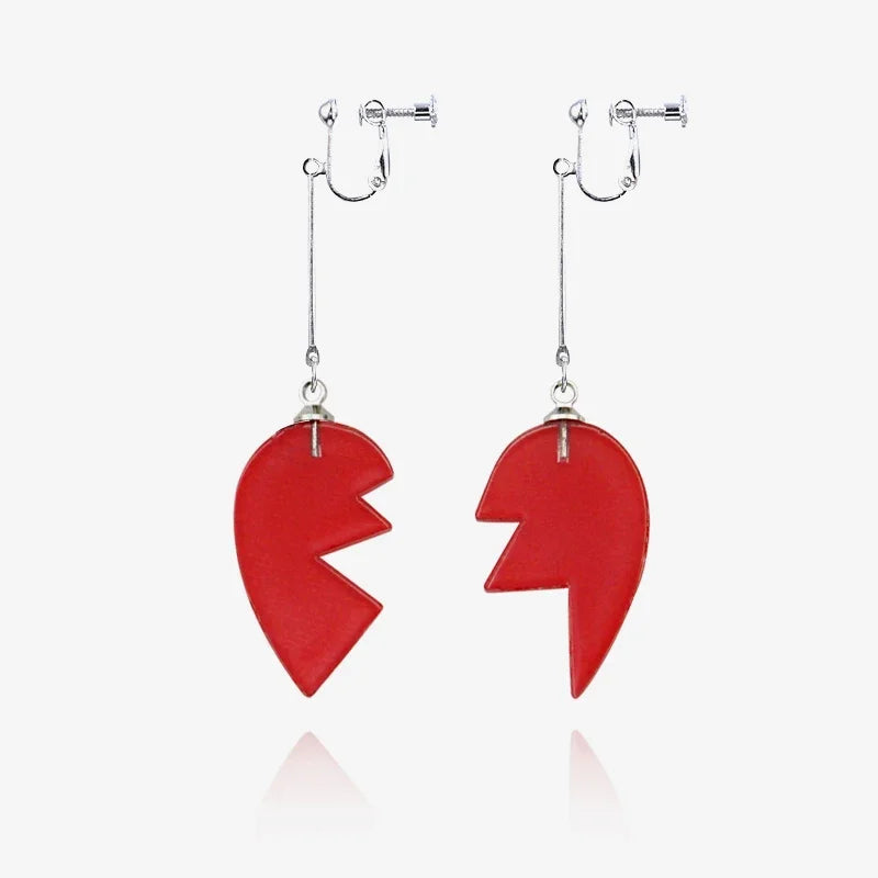 A pair of red stone pendants on silver chains, featuring a jagged, heart-like shape.