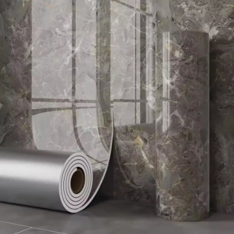 Roll of self-adhesive marble wallpaper showing a textured gray and white marble pattern against a dark gray wall.