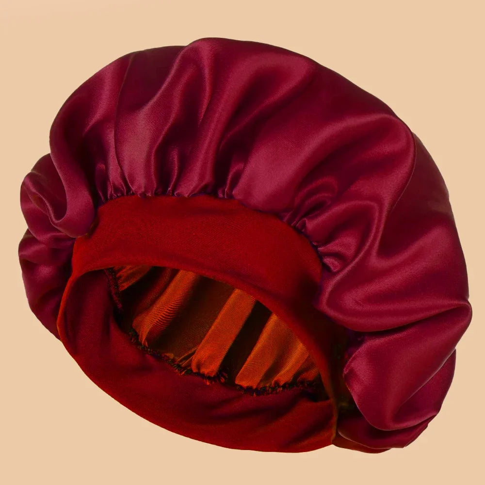 A deep burgundy satin wide brim shower cap folded and displayed against a light background.