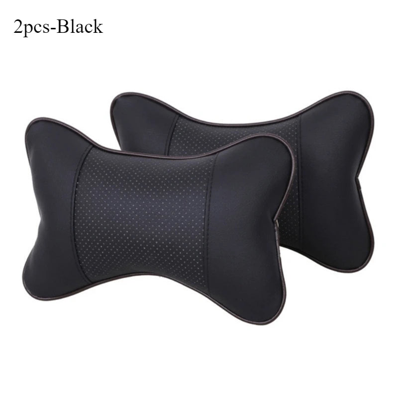 A pair of black leather knitted car neck pillows with a subtle dotted pattern.