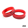 A pair of red aluminum knob trim covers for a Ford Mustang, shown against a white background.