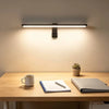 A modern LED light bar mounted above a wooden desk, illuminating the workspace.