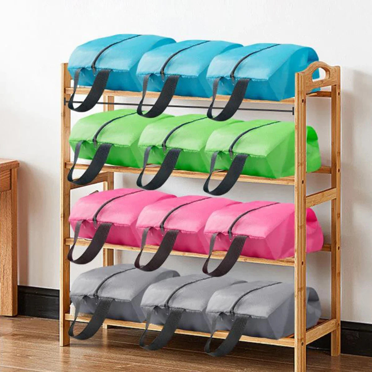 A wooden shelf displaying various colored foldable nylon shoe storage bags for waterproof protection.
