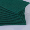 A stack of dark green microfiber kitchen scrub sponges for dishes and countertops.