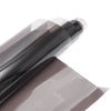 A roll of dark brown car window privacy film being peeled off a sheet.