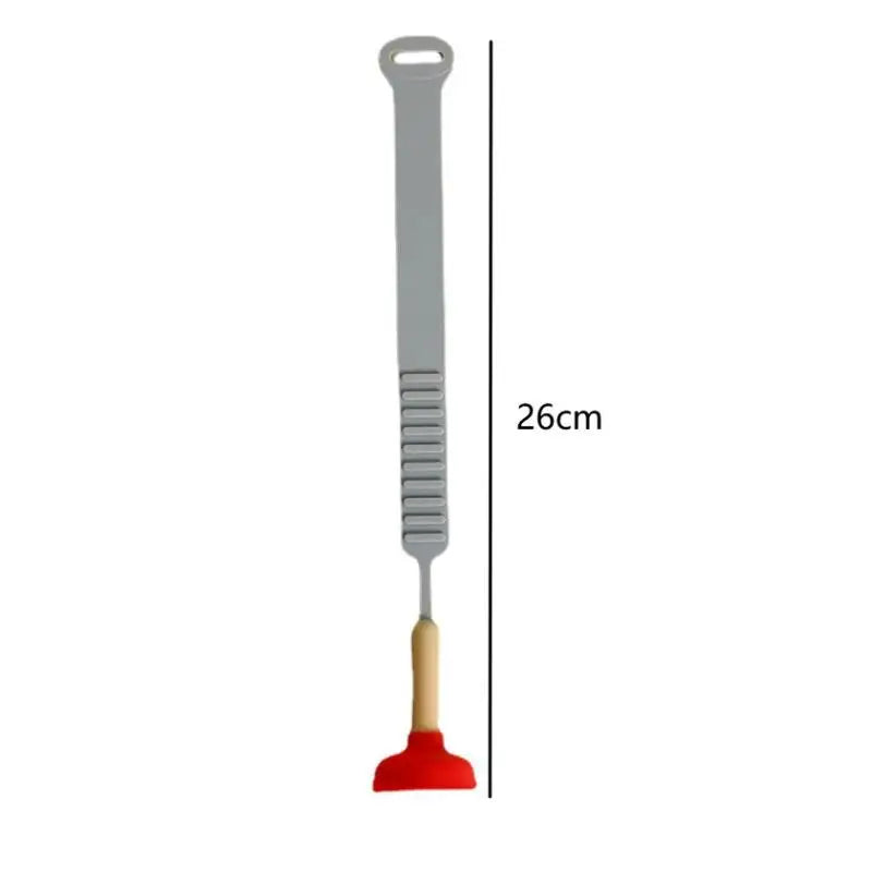 A gray hands-free toilet lid lifter tool with a long handle and a small red scoop.